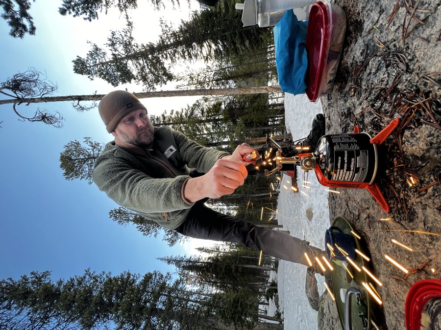 Lighting a camp stove at dusk