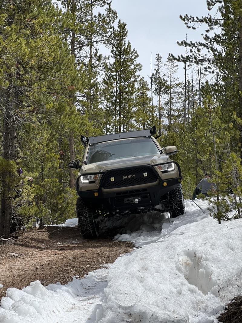 Truck pushing through deep snow on a forest road