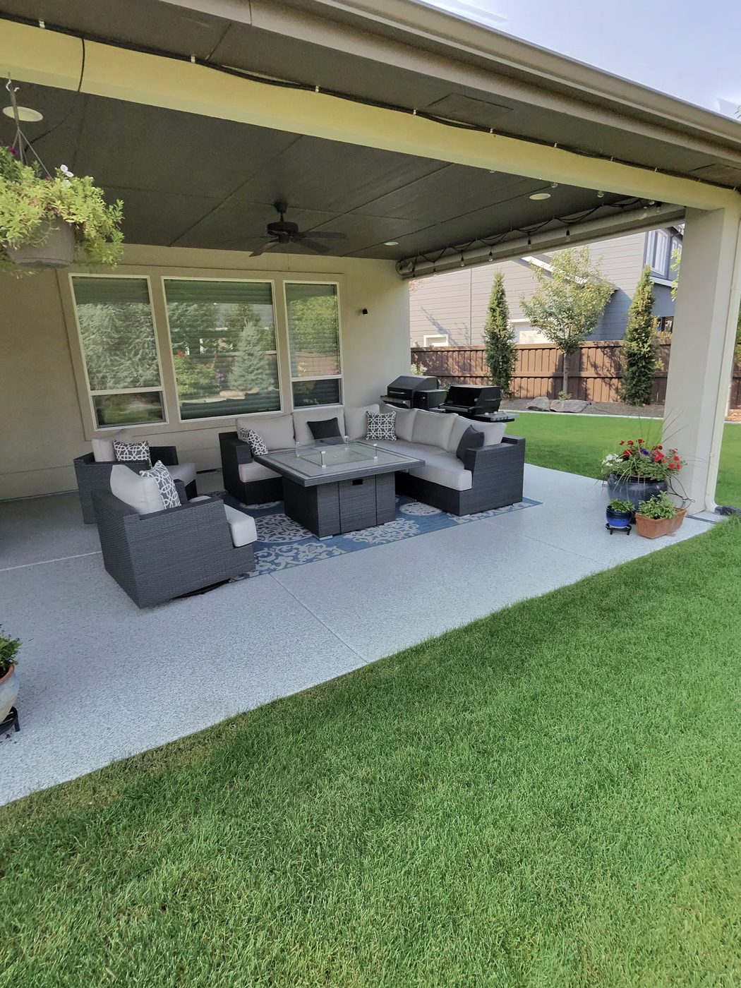 Covered back patio with outdoor furniture on a coated floor