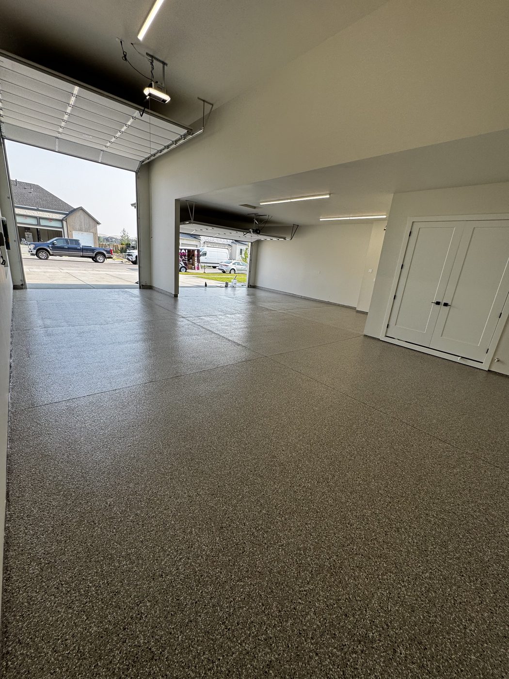 Finished garage floor looking out an open bay door